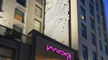 A modern building with a prominent neon sign and a large, illuminated fingerprint design on the facade.