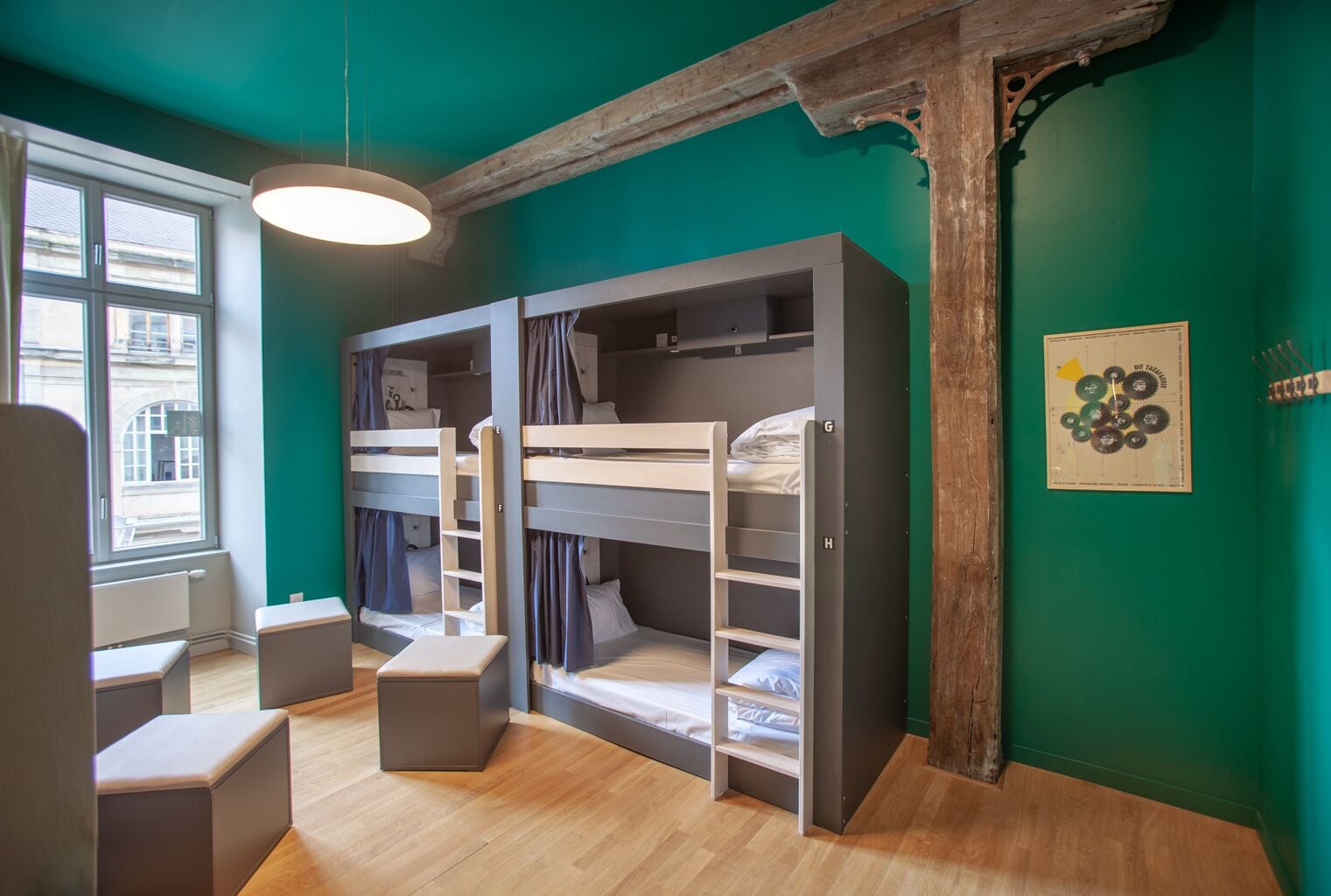 Une chambre avec des lits superposés, un bureau et une fenêtre.