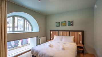 Une chambre à coucher avec un lit, une fenêtre et vue sur la rue.