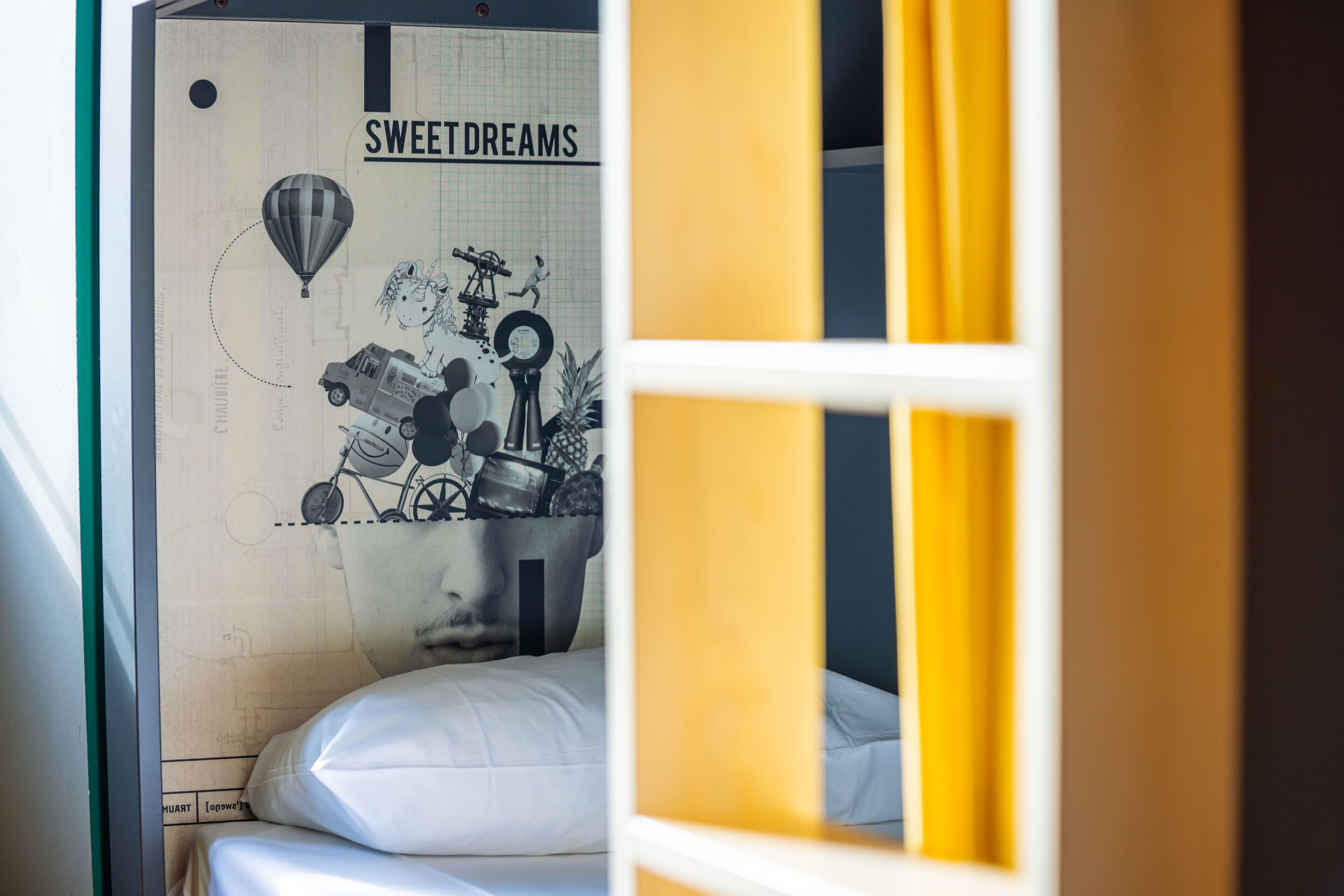 Une pièce avec un lit, un mur orné d’une affiche et une fenêtre avec des rideaux.