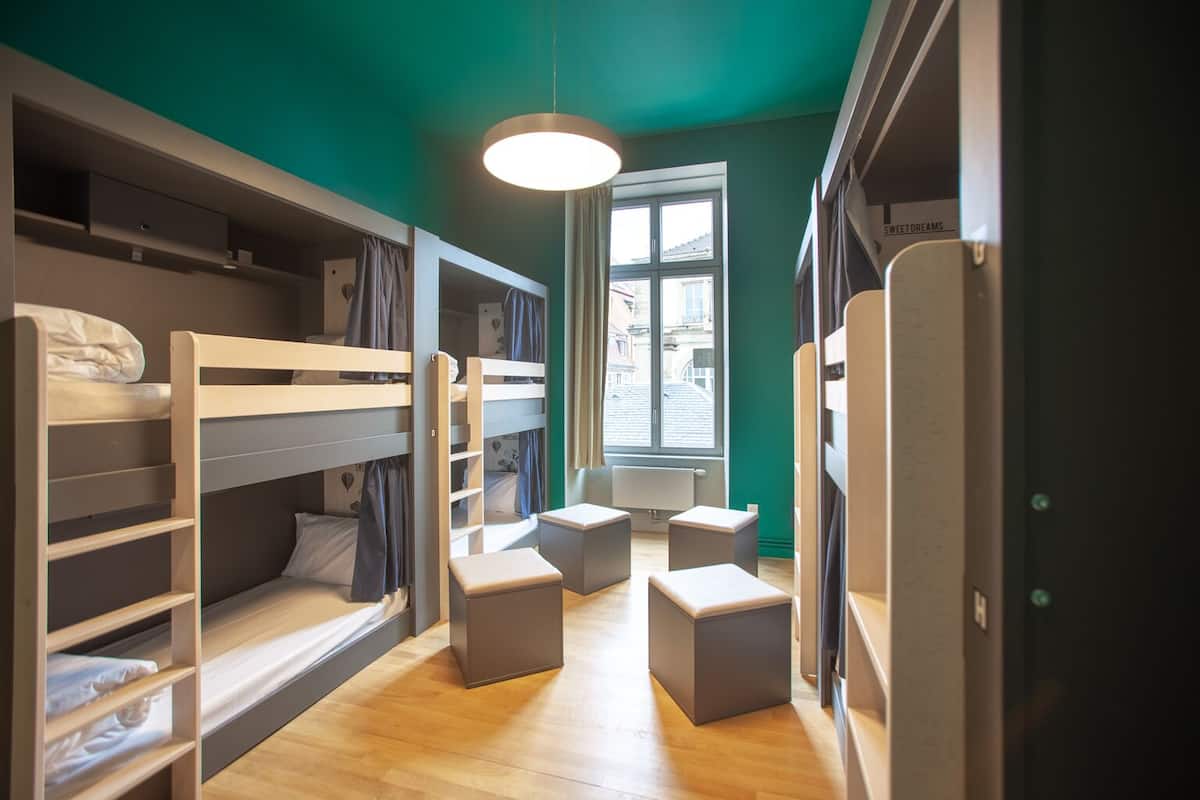 Ein Zimmer mit Etagenbetten, einem Fenster mit Blick und einer kleinen Sitzecke.
