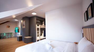 Ein modernes Hotelzimmer mit einem großen Bett, einem Schreibtisch und einem integrierten Kleiderschrank.