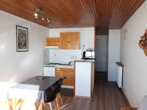 A compact kitchen with wooden cabinets, a microwave, and a small refrigerator. - Studio for 4 people at the foot of the slopes in Chamrousse (Chamrousse)