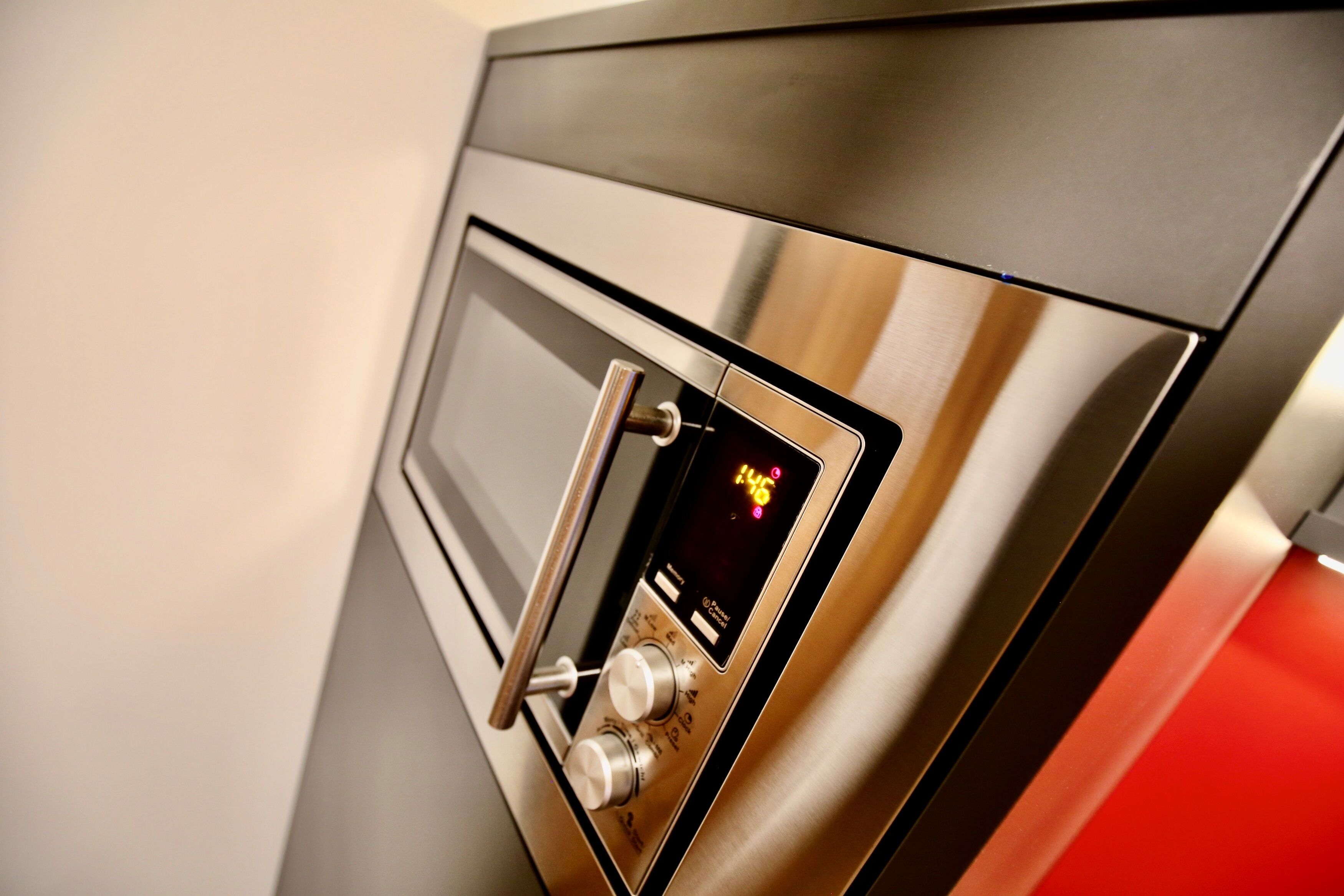 A stainless steel oven with a digital clock displaying 1:46.
