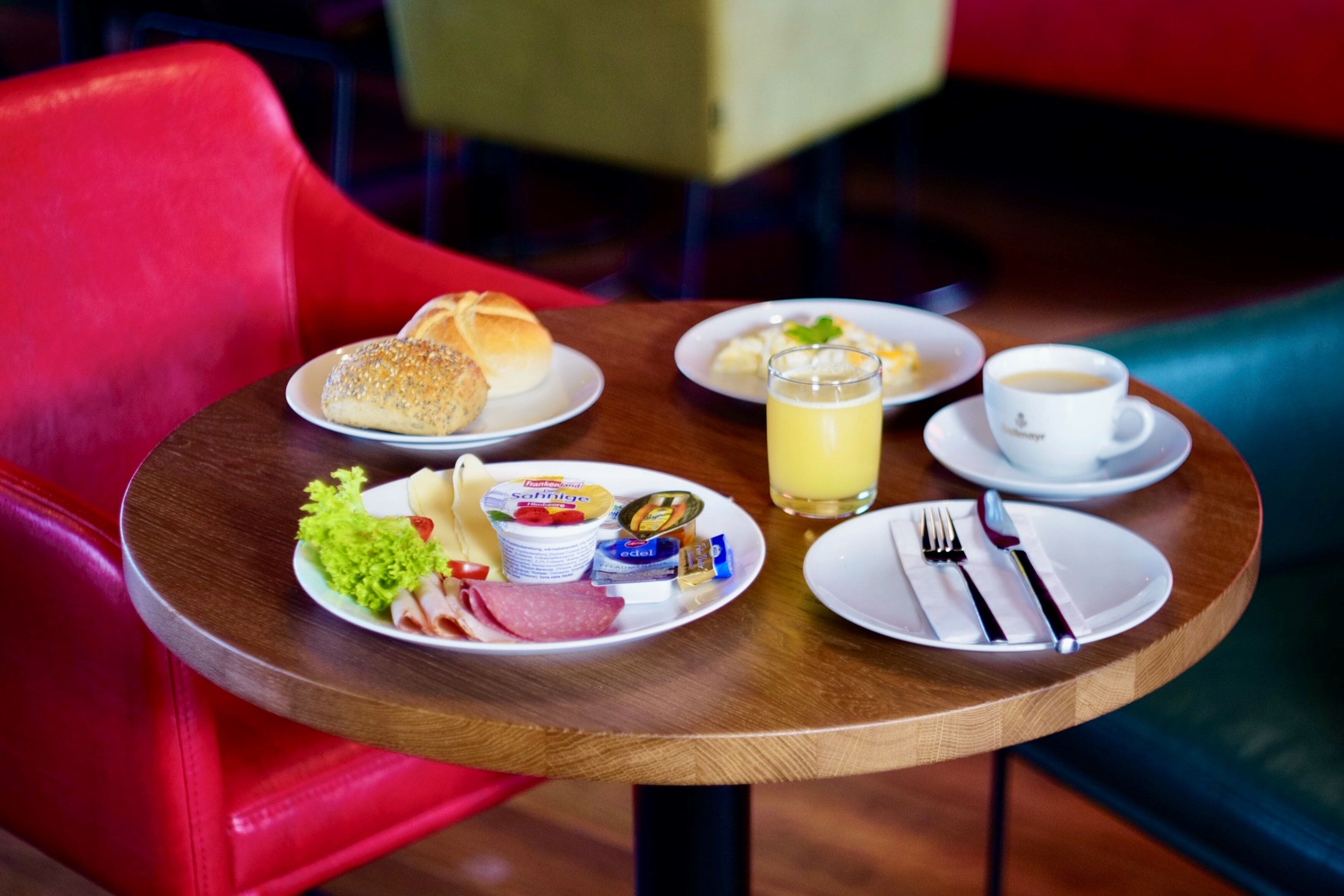 Una mesa con alimentos para el desayuno, como pan, una bebida y una taza de café.