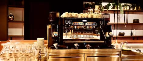 A coffee machine with multiple portafilters, a milk frother, and a steam wand.