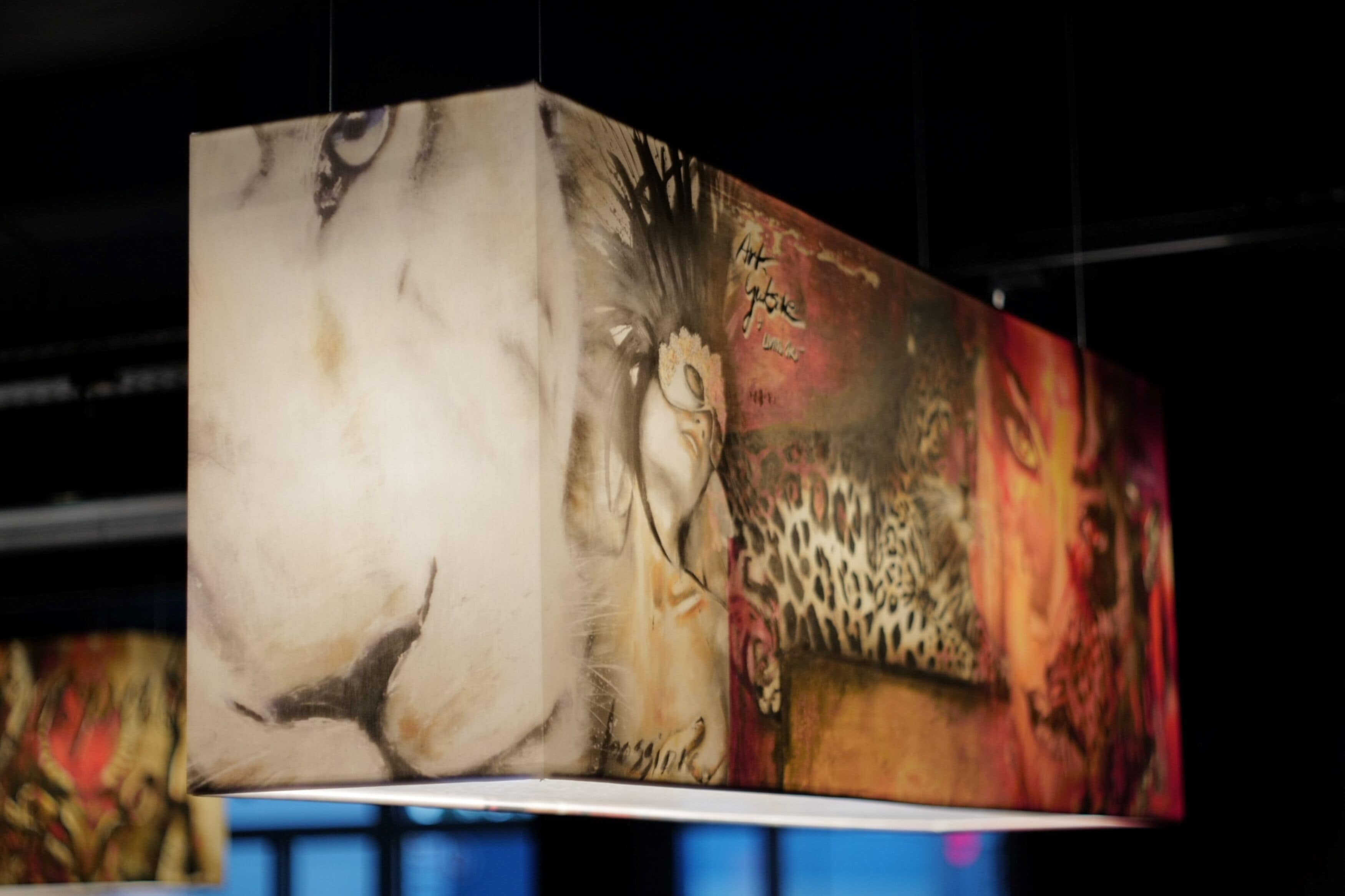 Una obra de arte grande, de varios paneles, con diversos elementos abstractos y figurativos, incluyendo un rostro y un estampado de leopardo.