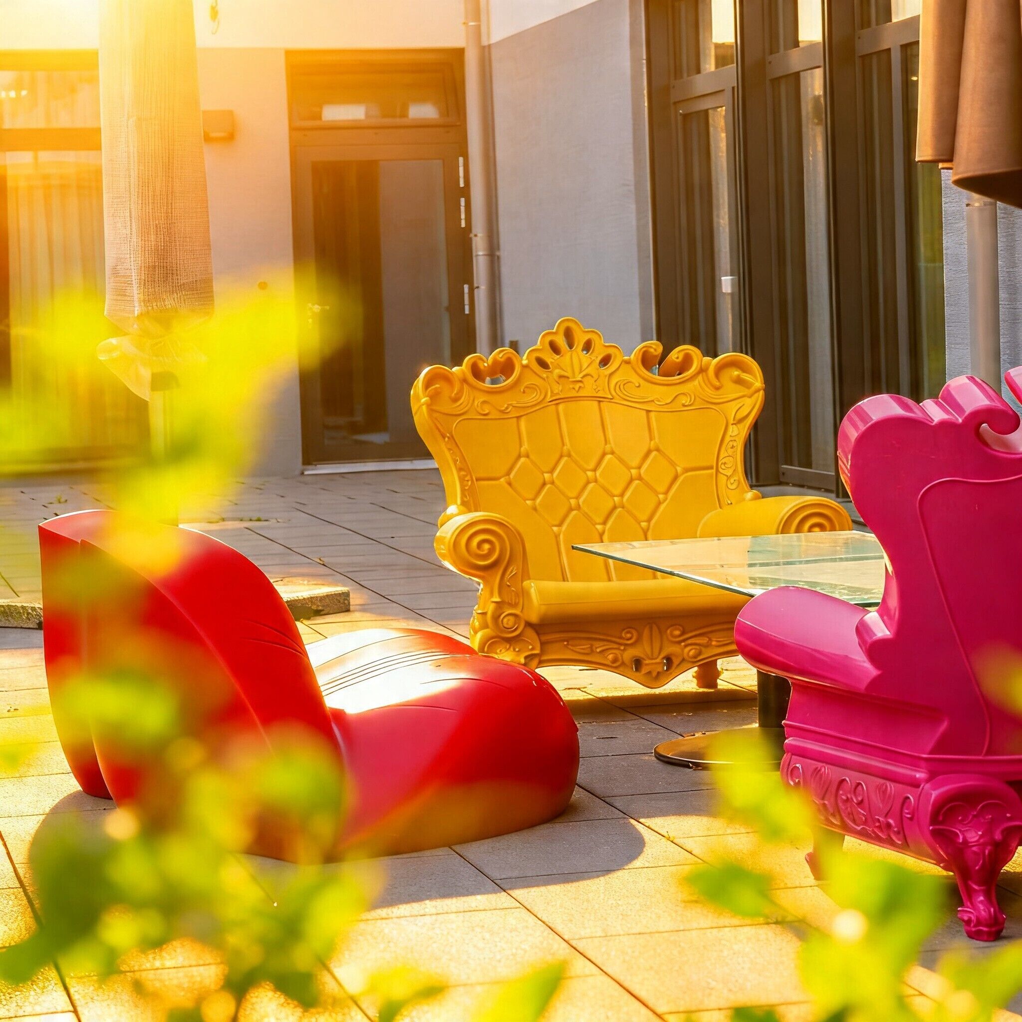 Outdoor seating with a glass table and chairs, a building entrance, and a door.