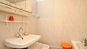 A bathroom with a sink, toilet, and bathtub. - Bright studio with loggia near slopes and shops (Chamrousse)