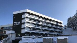 Eine mehrstöckige Tiefgarage mit schwarz-weißer Fassade, umgeben von Schnee.