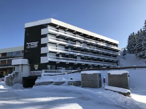 A multi-story parking garage with a black and white facade, surrounded by snow.