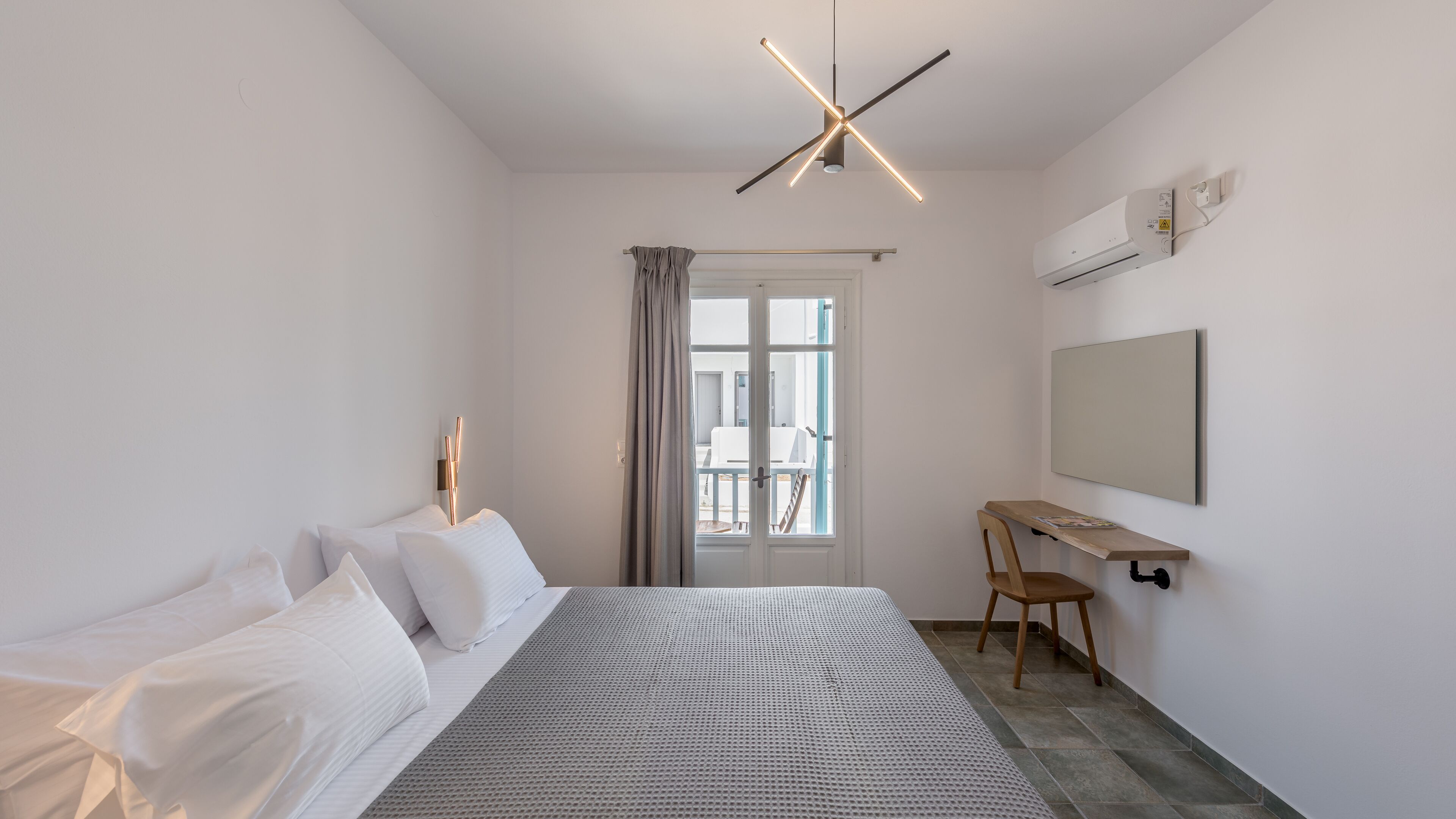 Un dormitorio moderno con cama, escritorio y ventana.