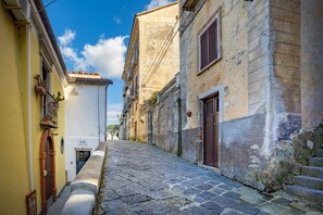 A narrow cobblestone street flanked by historic buildings with arched doorways and traditional balconies. - Borgo dei Saraceni - Flower Home (Agropoli)