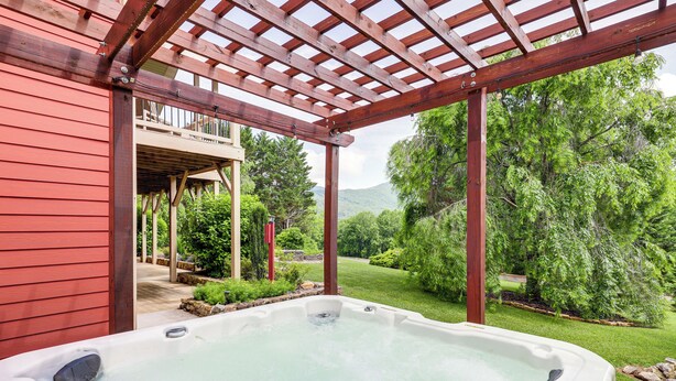 A hot tub under a wooden pergola with a view of a lush garden and a mountain in the background. - Mtn Views & Hot Tub: 6-Acre Blue Ridge Retreat! (Swannanoa)