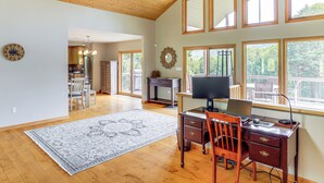 A spacious room with a wooden ceiling, large windows, a desk with a computer, and a dining area in the background. - Mtn Views & Hot Tub: 6-Acre Blue Ridge Retreat! (Swannanoa)