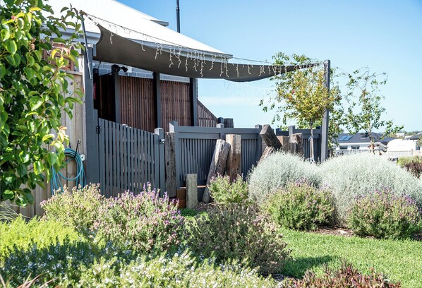 Relax in a serene garden setting surrounded by lush greenery and string lights.