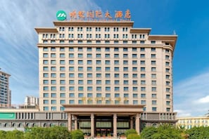 A multi-story hotel with a prominent entrance, large windows, and a clear sky. - Mingfa International Hotel (Hefei)