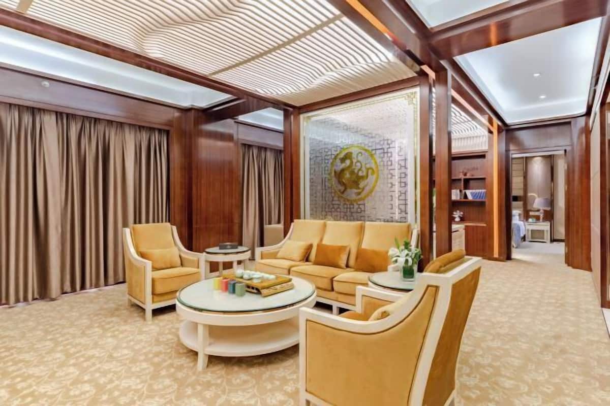 A spacious living area with a sofa set, armchairs, and a coffee table.