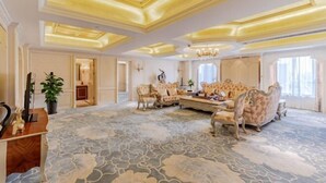 Een ruime kamer met een kamerbreed tapijt, een gedecoreerd plafond en klassiek meubilair.