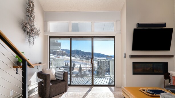 Un salon moderne avec un canapé, une table basse et un téléviseur fixé au mur.
