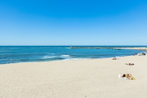 A wide sandy beach with a clear blue sky and calm sea. - Aguda Beach Apartment (Vila Nova de Gaia)