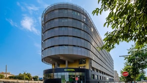 Un hotel moderno con fachada curva, varios pisos y una entrada destacada.