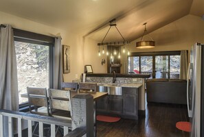 Eine moderne Küche mit einer zentralen Kochinsel, Holzkästen und einer Hängeleuchte.