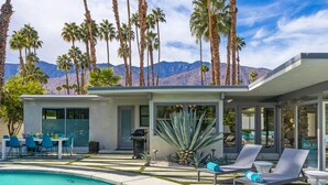 A modern house with a pool, lounge chairs, and palm trees. - Marcia! Marcia! Marcia! – Mid-Mod PS Retreat (Palm Springs)