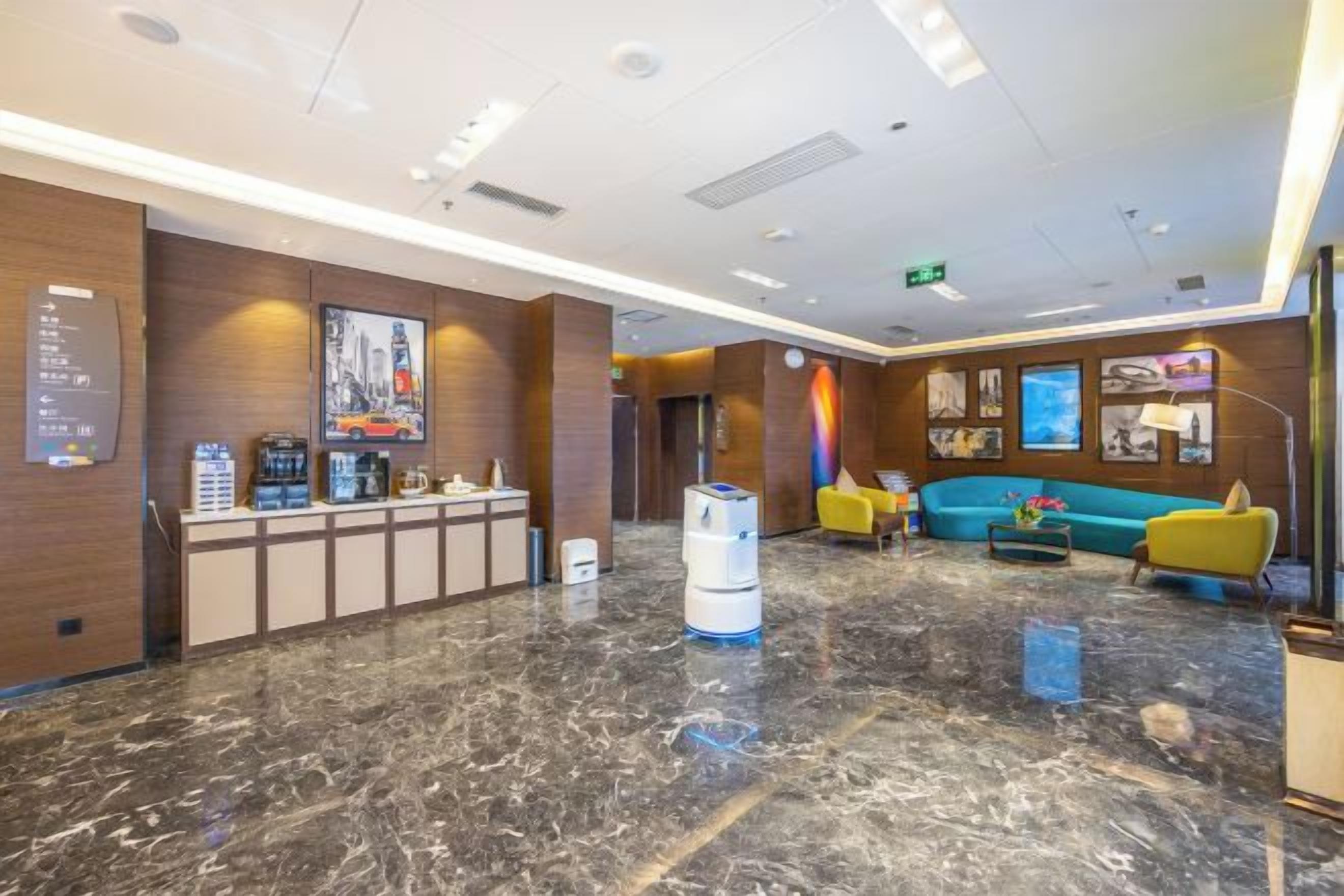 Eine Hotelhalle mit Rezeption, Sitzgelegenheiten und einer Kaffeemaschine.