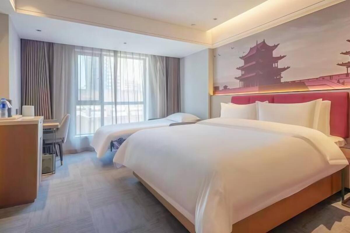 A hotel room with a bed, a desk, and a chair.