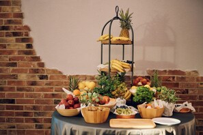 A fruit and vegetable display on a table with a brick wall background. - Paris (Opatija)