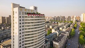 Un hôtel à plusieurs étages, doté d’une façade incurvée, de nombreux balcons et offrant une vue dégagée sur le paysage urbain environnant.