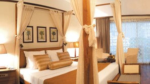 A four-poster bed with a canopy, a nightstand with a lamp, a chair, and a small table with fruit.