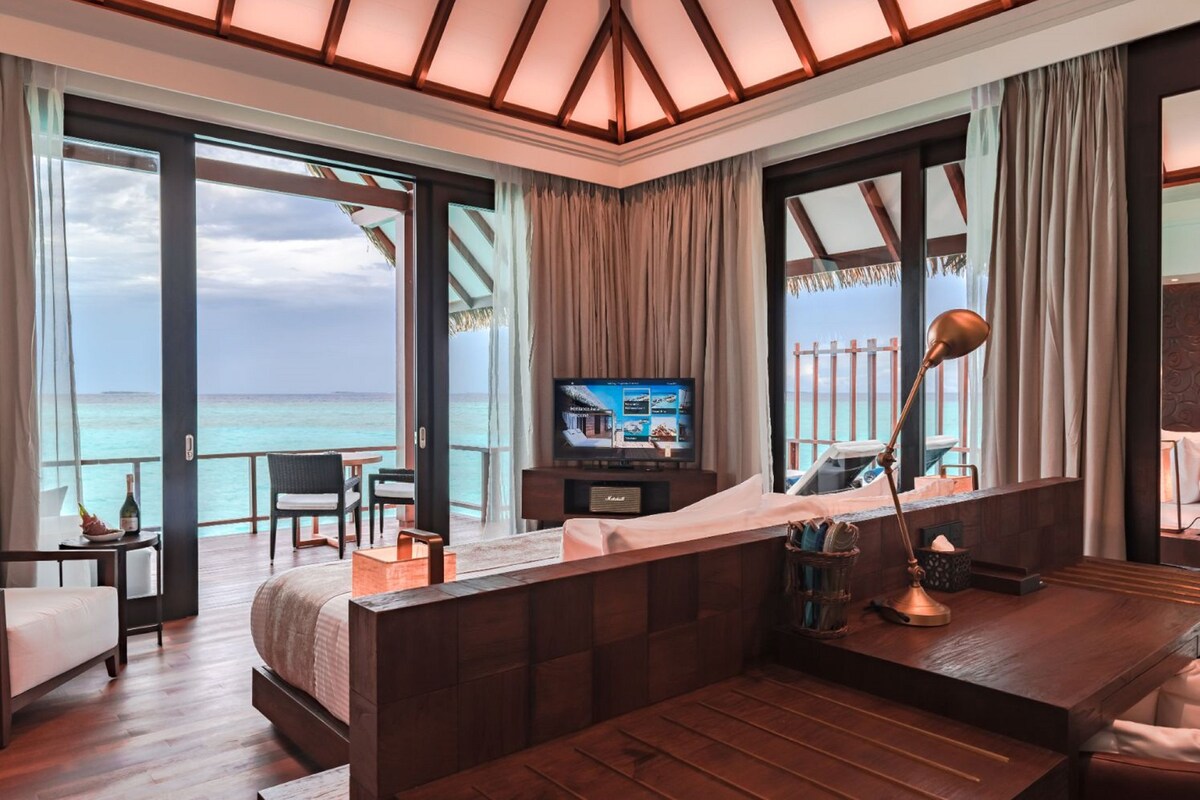 Ein Hotelzimmer mit Bett, Schreibtisch, Fernseher und Meerblick.