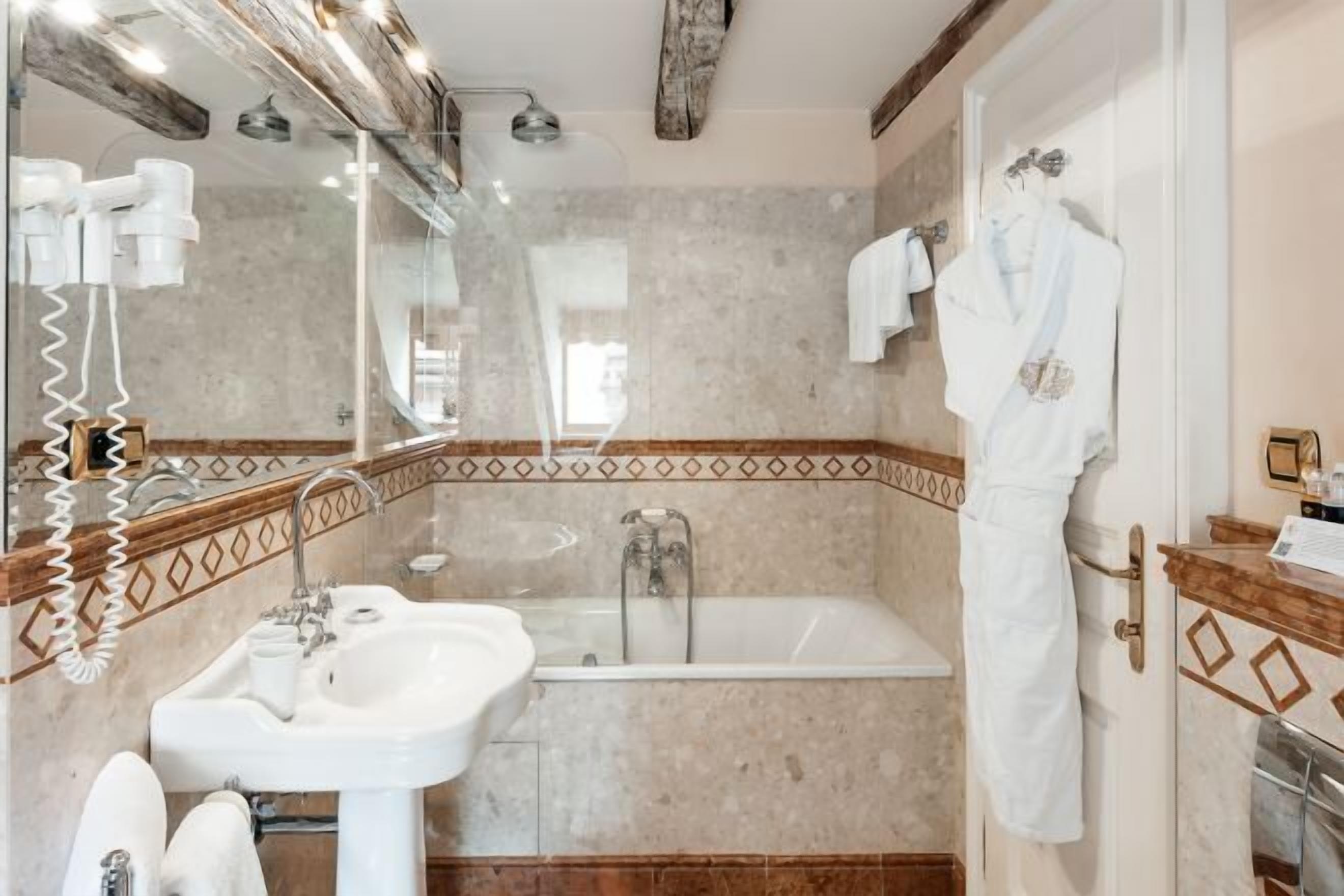 A bathroom with a sink, mirror, and bathtub.