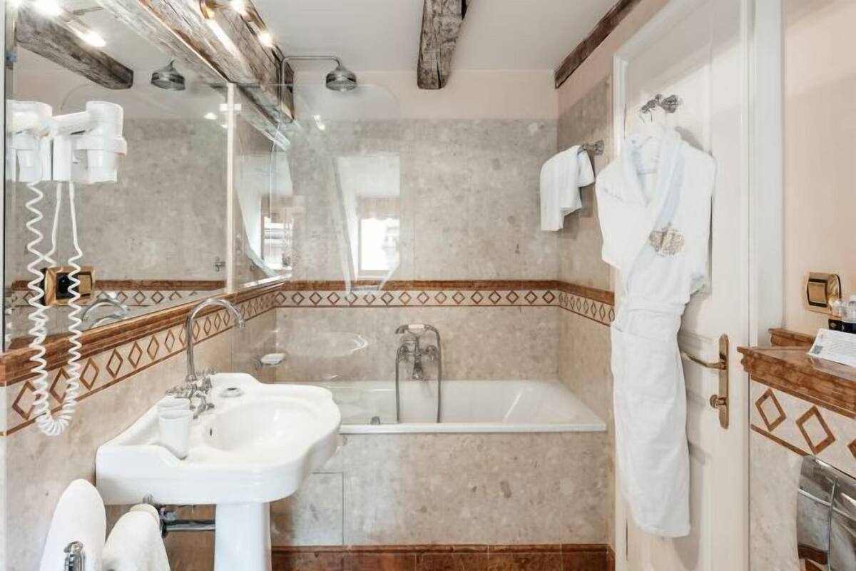 Une salle de bain avec un lavabo, un miroir et une baignoire.
