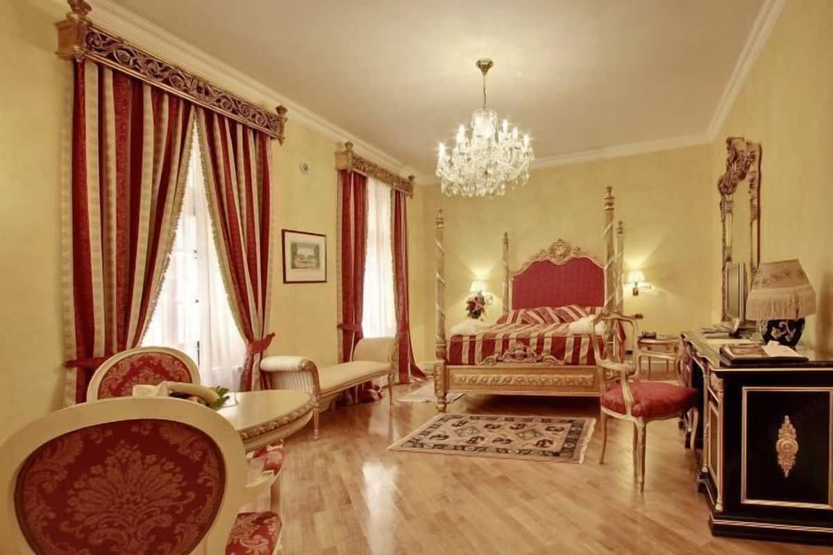 Une chambre à coucher avec un grand lit, un lustre et un décor classique.