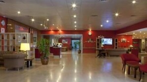 A spacious lobby with a reception desk, seating area, and a large television screen. - Inn And Go Kuwait Plaza Hotel (Kuwait City)