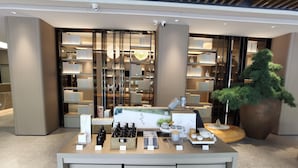 A modern retail space with shelves of products, a display counter with items, and a large potted plant. - Ji Hotel (Xiamen)