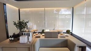 A modern interior with a sofa, a dining table, and a potted plant. - Ji Hotel (Xiamen)