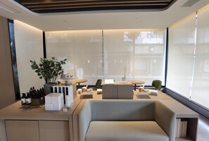A modern interior with a sofa, a dining table, and a potted plant. - Ji Hotel (Xiamen)