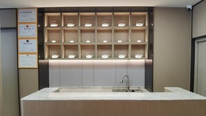 A modern kitchen with a central island, built-in shelves with tea lights, and a sink. - Ji Hotel (Xiamen)