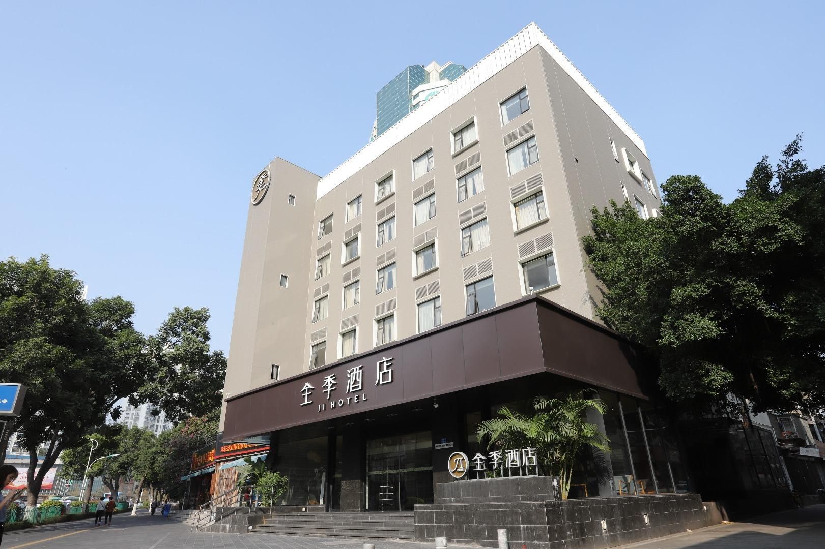 A hotel with a modern facade, multiple floors, and a prominent entrance with a sign.
