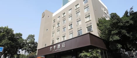 A hotel with a modern facade, multiple floors, and a prominent entrance with a sign.