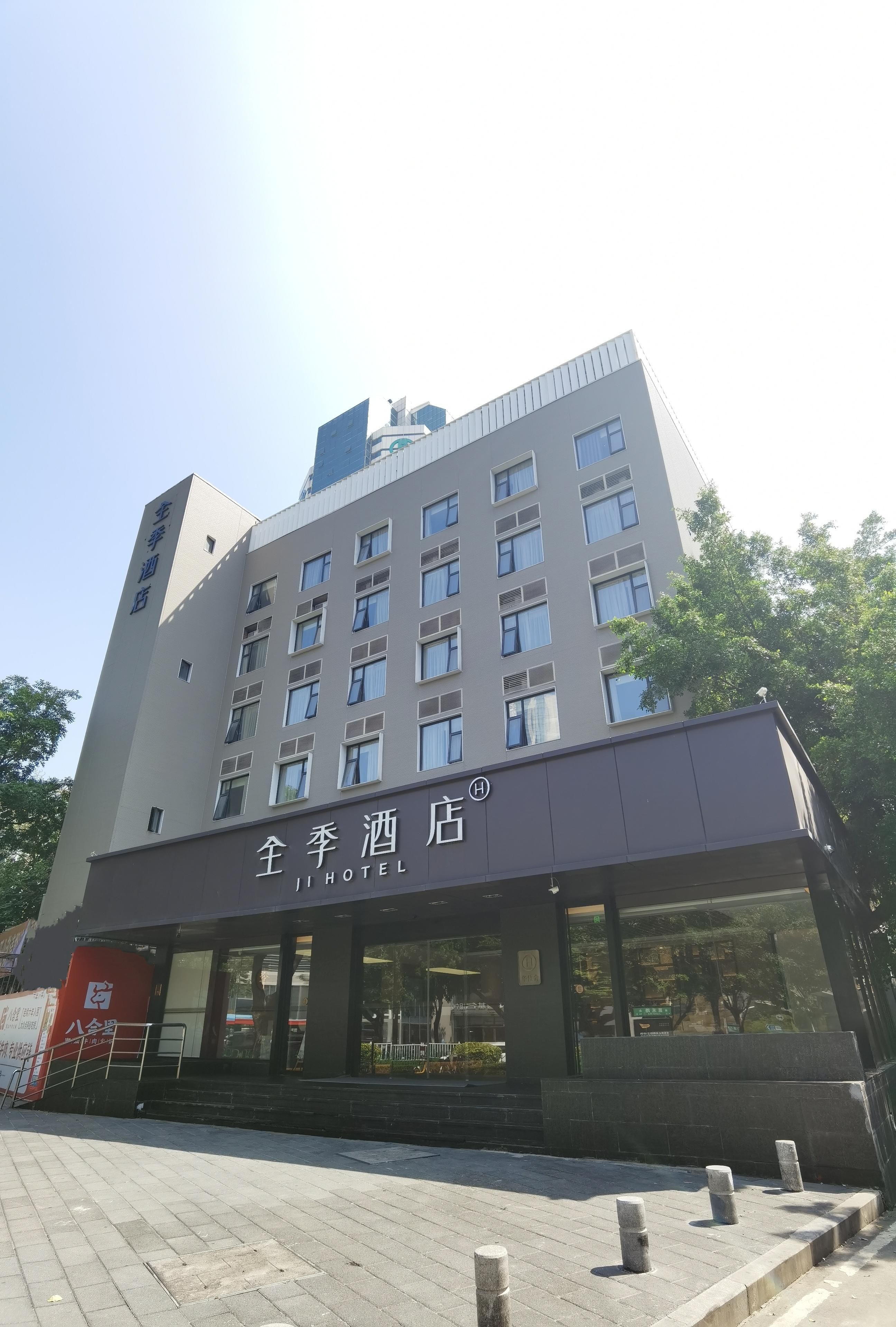 A hotel building with multiple floors, large windows, and a sign indicating it is a hotel.
