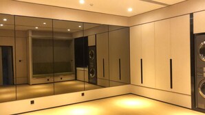 A modern, well-lit room with a large mirror, a washing machine, and a built-in bench. - Ji Hotel (Xiamen)