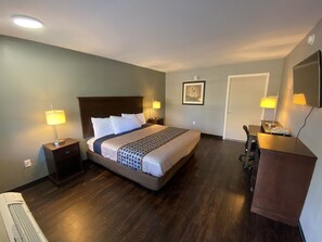 A hotel room with a bed, nightstands, a desk, and a chair. - Americas Best Value Inn Gainesville (Gainesville)