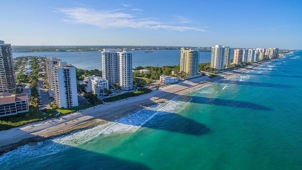 A coastal high-rise hotel with multiple floors, a beachfront promenade, and a view of the ocean. - Dreamy Singer Island Beach Retreat (Singer Island)
