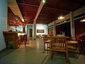 Un restaurant avec des meubles en bois, un comptoir et un plafond orné de poutres en bois.