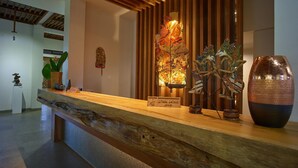 Ein Empfangsschalter mit Holzausstattung, eine Wanddekoration und eine große Vase.